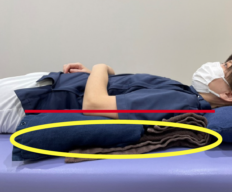 肩と肘が同じ高さ（赤線）になるように、黄色の丸の部分にクッションやバスタオルを置きます。肩甲骨の下にも置くことで、安定性を高めることができます。