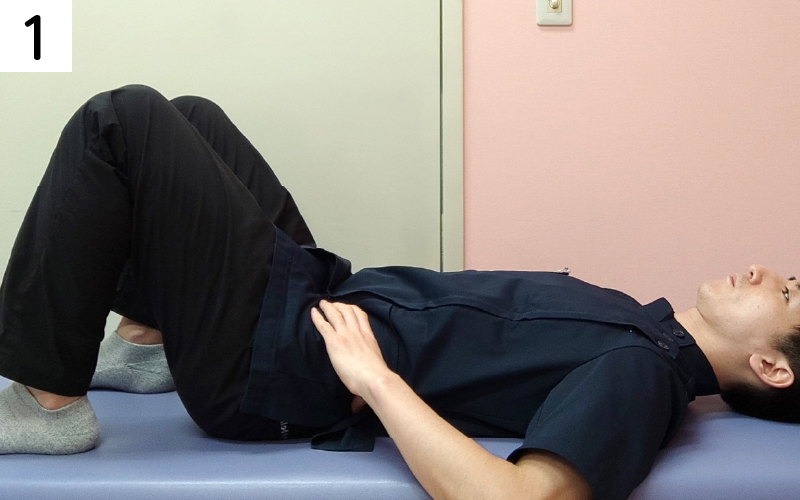 膝を立てて寝ます。おへそより下の位置で左右のお腹に手を置きます。
