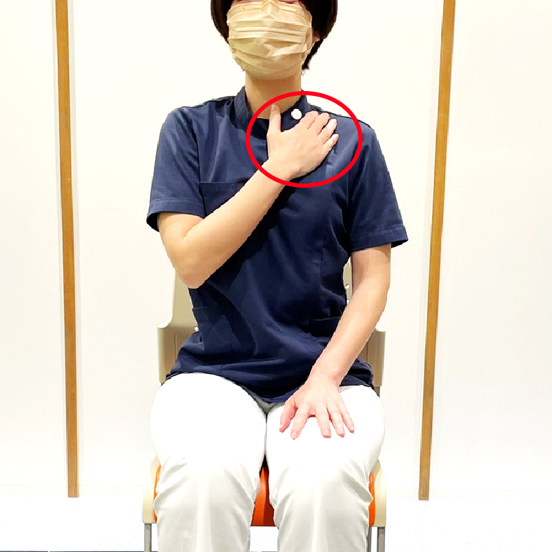 痛みのある側の鎖骨の下に反対側の手を置き、胸の部分を軽く固定します。